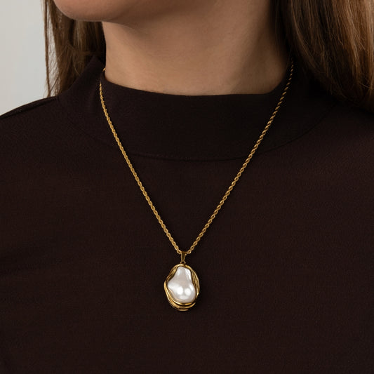 Colar Aurora Pearl com pendente de pérola orgânica e malha torcida dourada.