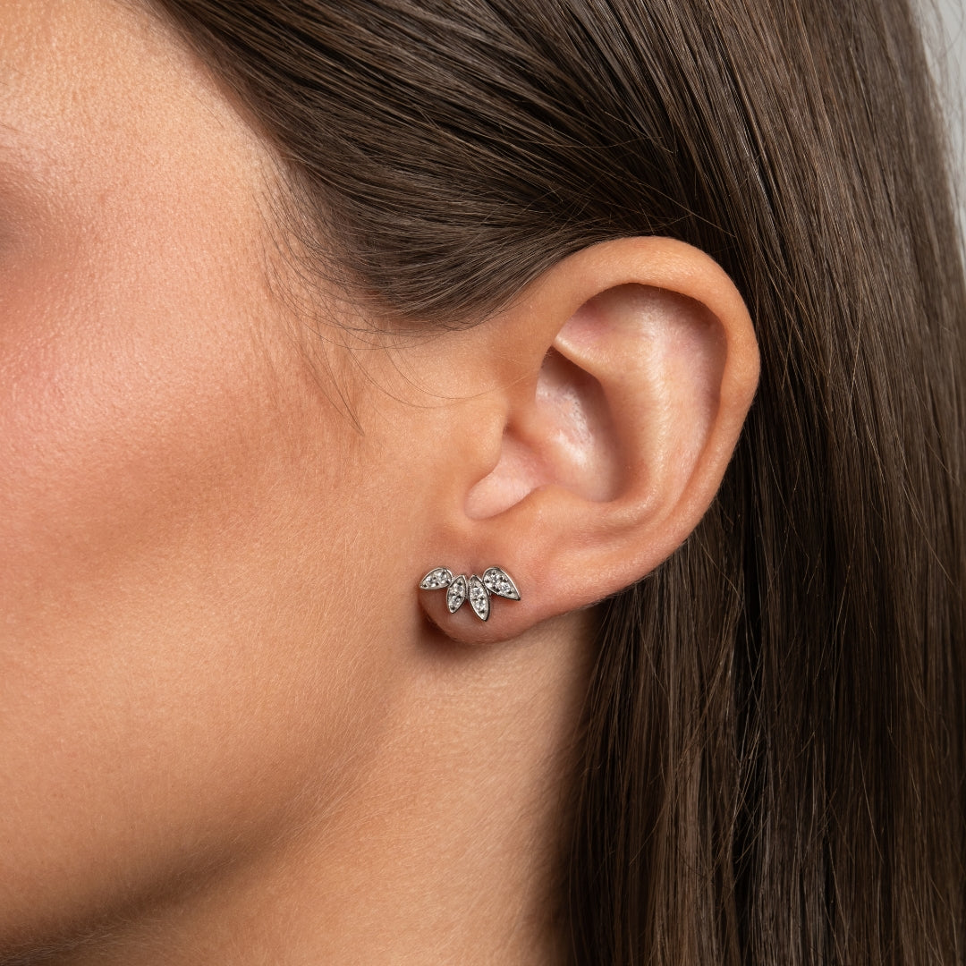 Close-up de Brincos Trepadores Crystal Petals em Prata de Lei 925 com 5 zircónias cravejadas em formato de pétala, usados na orelha de uma mulher