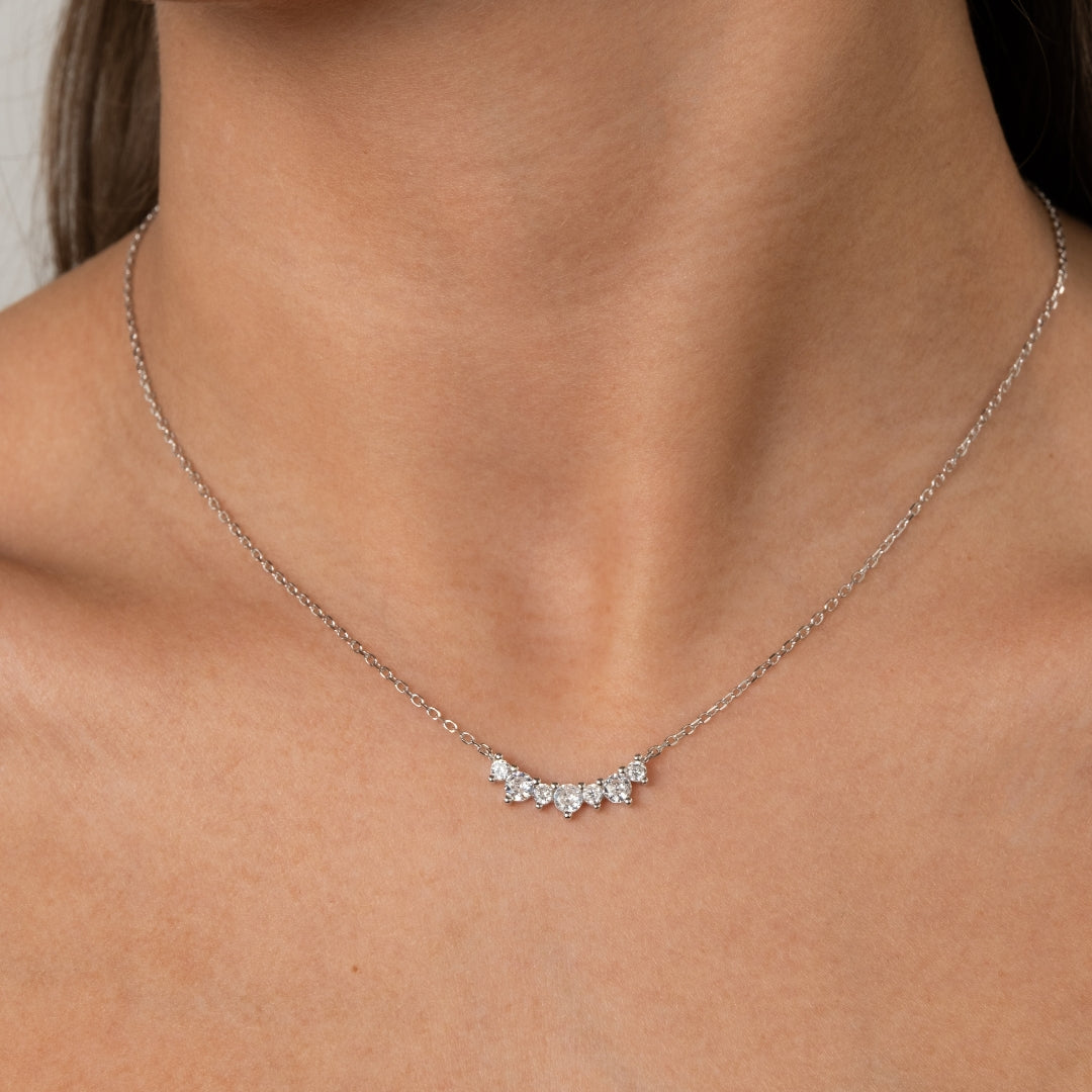 Close-up de Colar em Prata de Lei 925 com 7 zircónias cravejadas em formato curvo, usado no pescoço de uma mulher