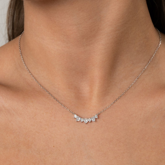 Close-up de Colar em Prata de Lei 925 com 7 zircónias cravejadas em formato curvo, usado no pescoço de uma mulher