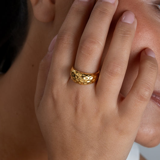 Anel Cratera em aço inoxidável dourado e prateado com textura martelada alveolar coleção Fuse joalharia contemporânea.