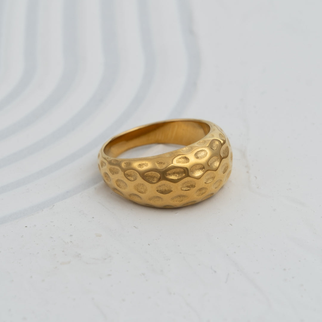 Anel Cratera em aço inoxidável dourado e prateado com textura martelada alveolar coleção Fuse joalharia contemporânea.