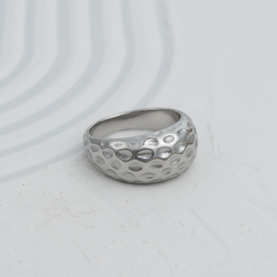 Anel Cratera em aço inoxidável dourado e prateado com textura martelada alveolar coleção Fuse joalharia contemporânea.