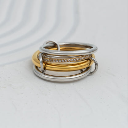 Anel Link bicolor em aço inoxidável com quatro aros interligados dourado prateado e zircónias coleção Fuse.