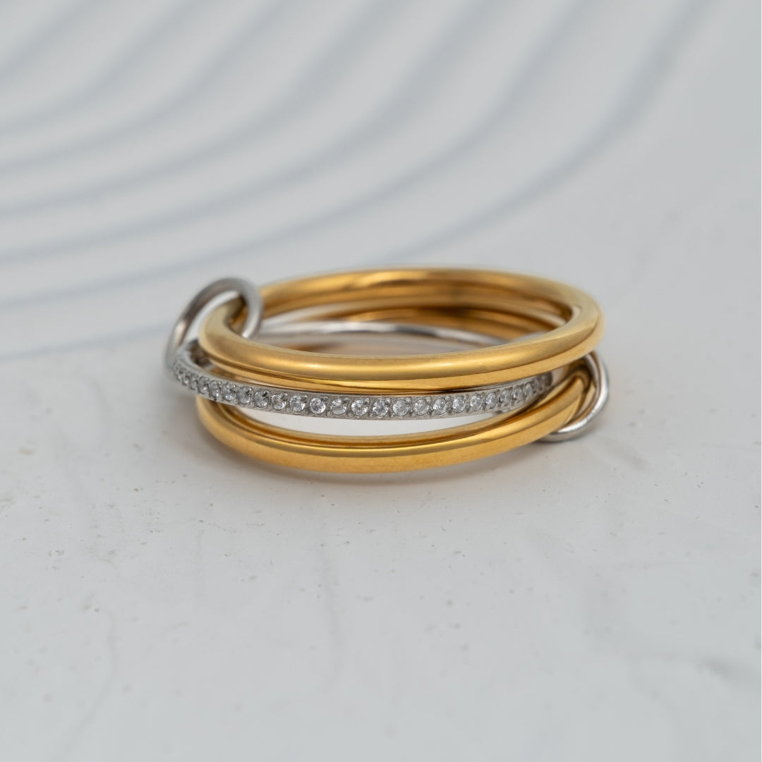 Anel Bond em aço inoxidável bicolor com três aros unidos por elos banho de ouro e zircónias coleção Fuse.