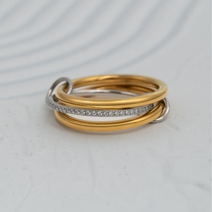 Anel Bond em aço inoxidável bicolor com três aros unidos por elos banho de ouro e zircónias coleção Fuse.