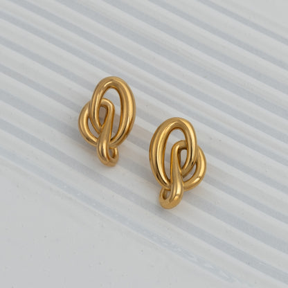 Brincos Chrome Flow em aço inoxidável dourado e prateado design de nó fluido coleção Fuse joalharia contemporânea.