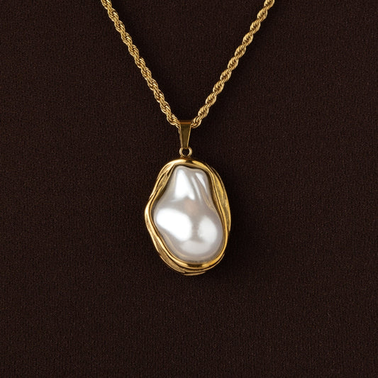 Colar Aurora Pearl com pendente de pérola orgânica e malha torcida dourada.