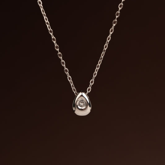 Colar prateado em aço inoxidável com pendente de gota lisa e volumosa com pedra zircónia cravada.